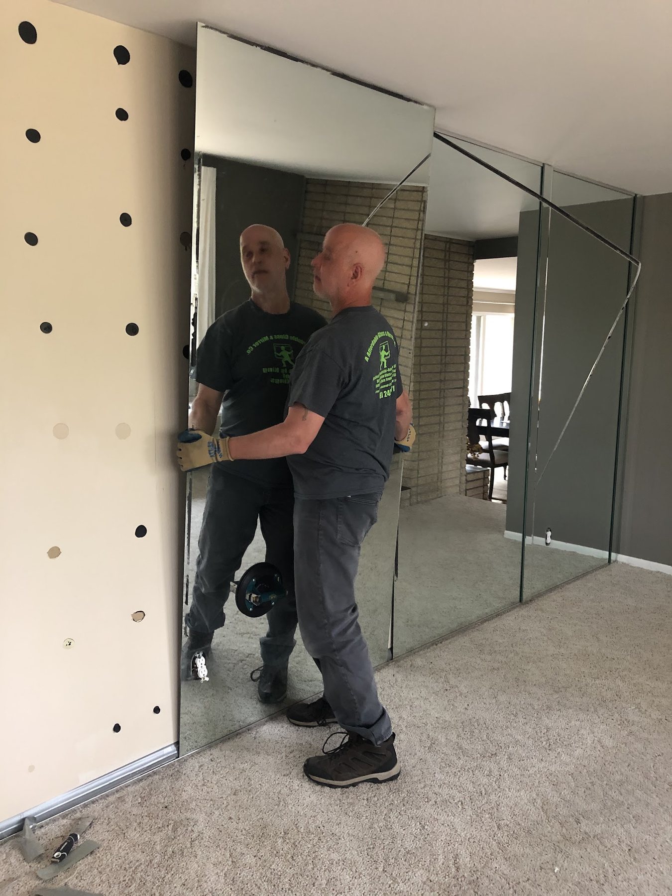 Charles and Greg carrying a large mirror panel into place