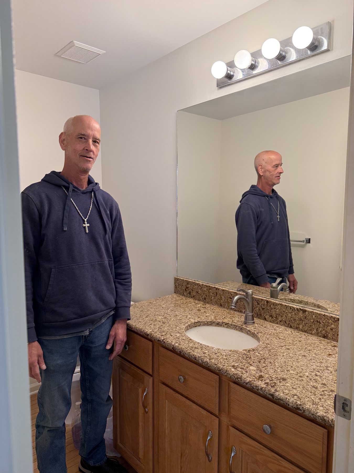 Charles Smith, owner of A Affordable Glass & Mirror Co., beside a newly installed bathroom mirror