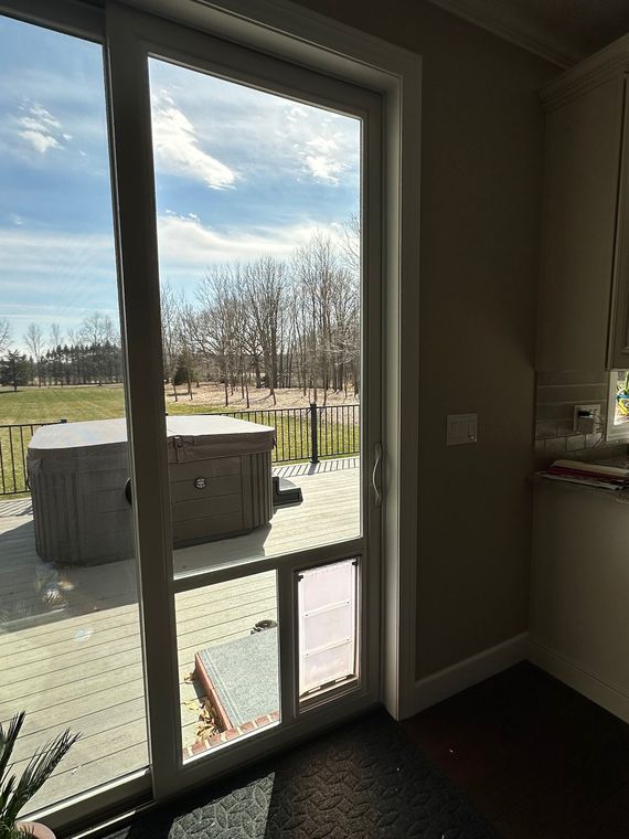 Glass door wall looking out to a deck and hot tub