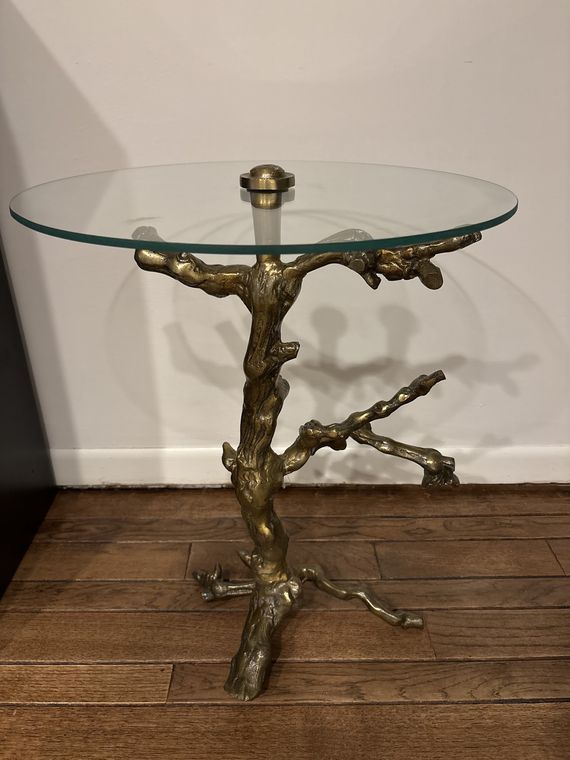 Round glass top on a sculptural brass table base