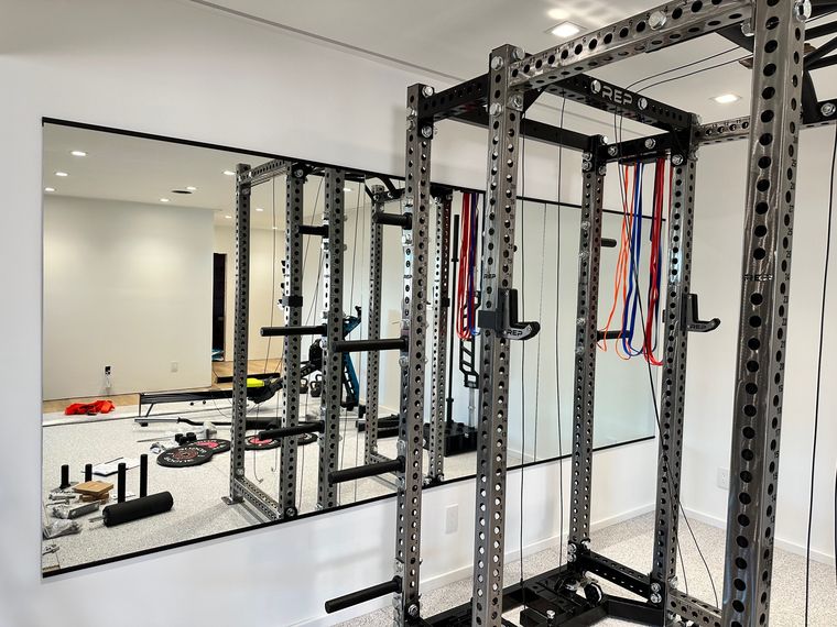 Mirrored wall behind a home gym squat rack