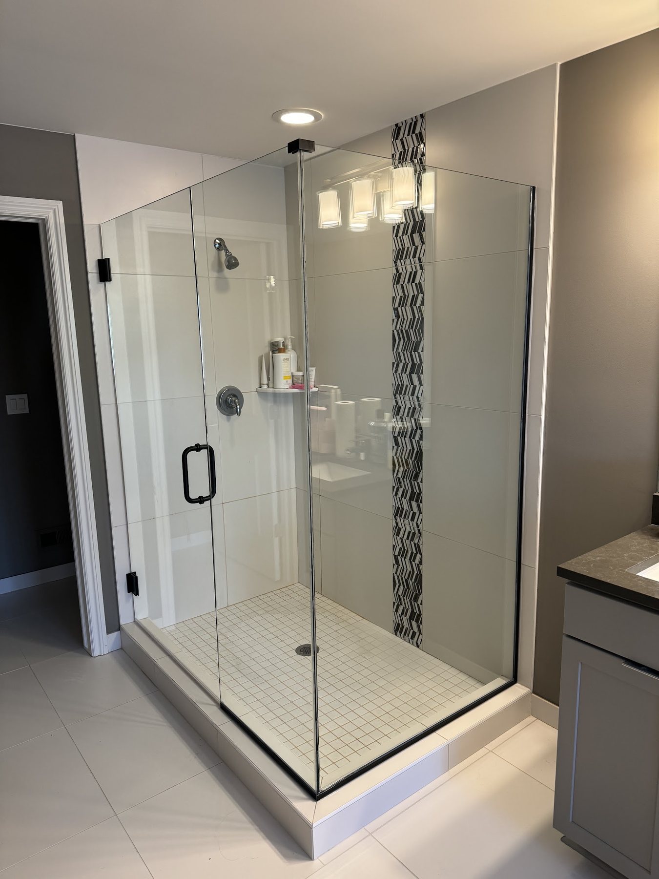 Frameless corner shower enclosure with tile surround