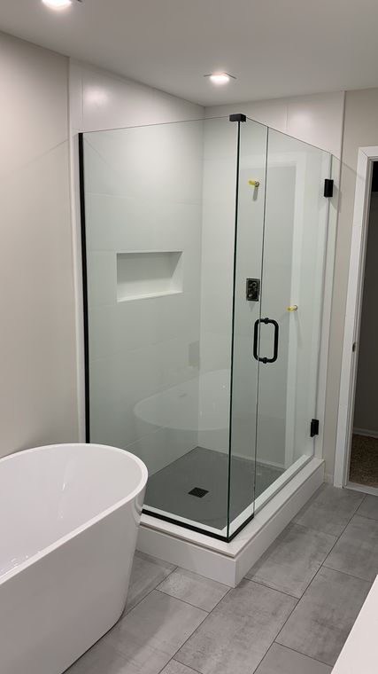 Frameless glass shower enclosure next to a freestanding tub